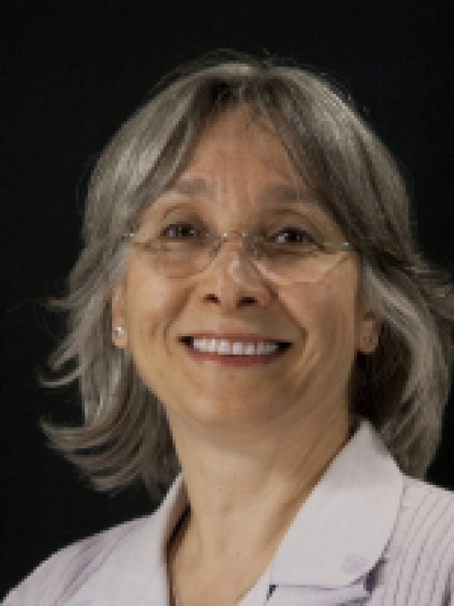 headshot of female with shoulder length grey hair wearing eyeglasses