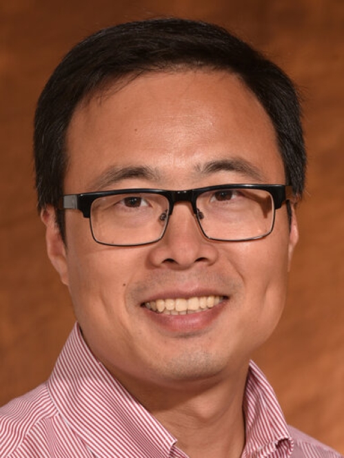 smiling Asian man with short black hair and eyeglasses