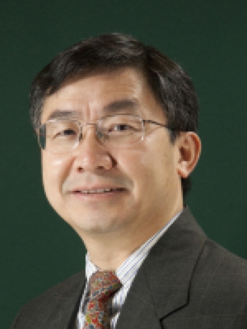 headshot of Asian male with eyeglasses wearing a dark suit and tie