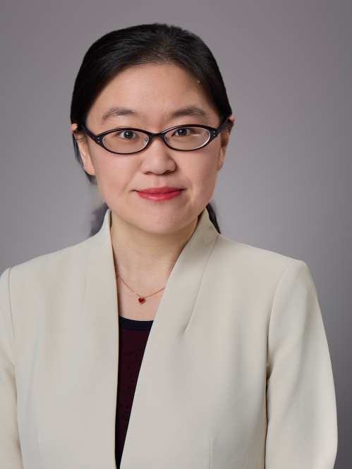 Headshot of woman with black hair pulled back and glasses. She is wearing a white jacket and black shirt.