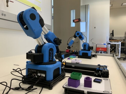 Two blue robotic arms on a table.