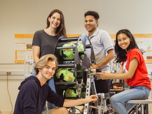 two female and two male students working on a senior design smart volleyball collector project