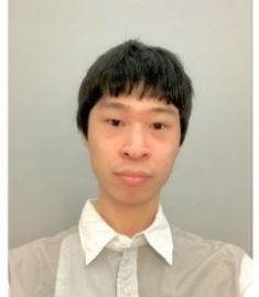 Headshot of male with short black hair with bangs and wearing a colored shirt.